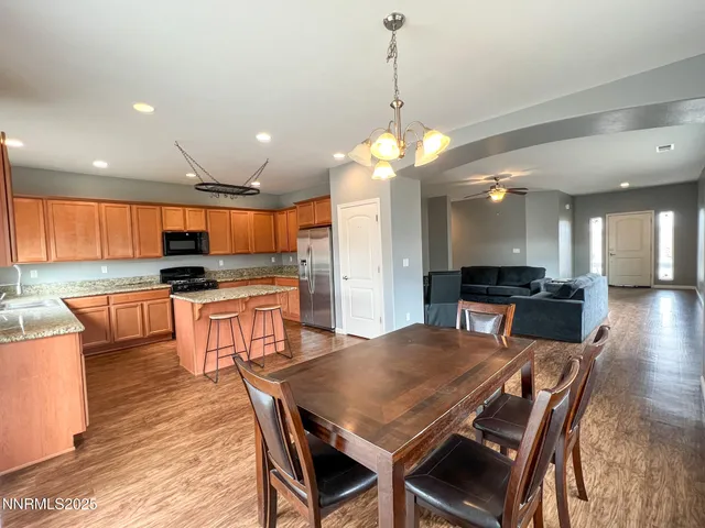 a view of a dining room and livingroom with furniture wooden floor a chandelier