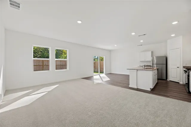 a view of a kitchen with a sink and dishwasher a kitchen island with wooden floor
