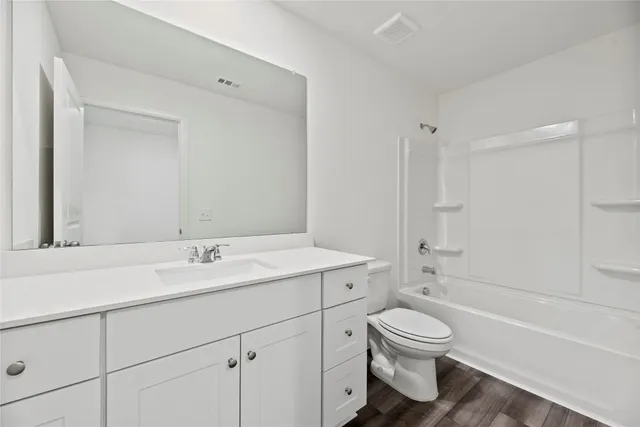 a bathroom with a toilet sink a mirror and shower