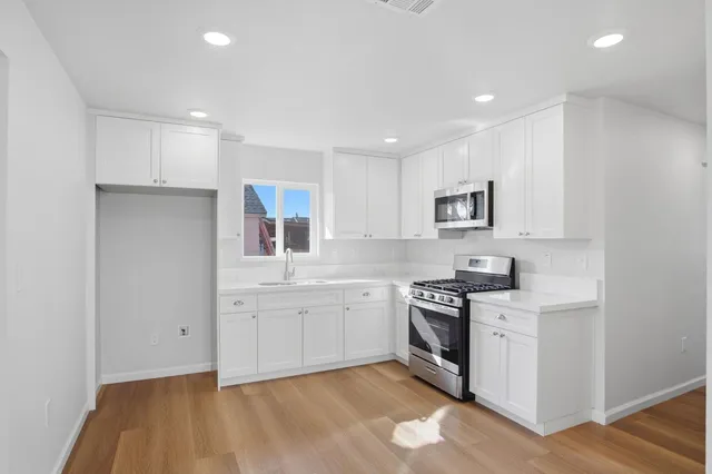 a kitchen with a sink stove and cabinets