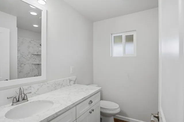 a bathroom with a sink toilet vanity and shower
