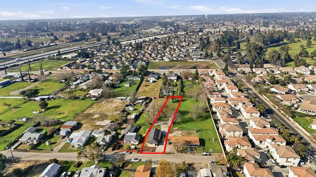 an aerial view of a house with a yard and street