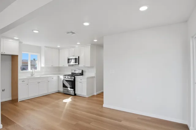 a large kitchen with a refrigerator and a stove top oven