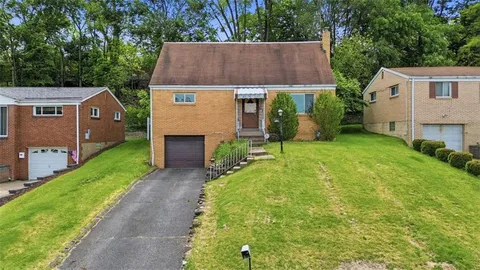 a aerial view of a house next to a yard and large tree