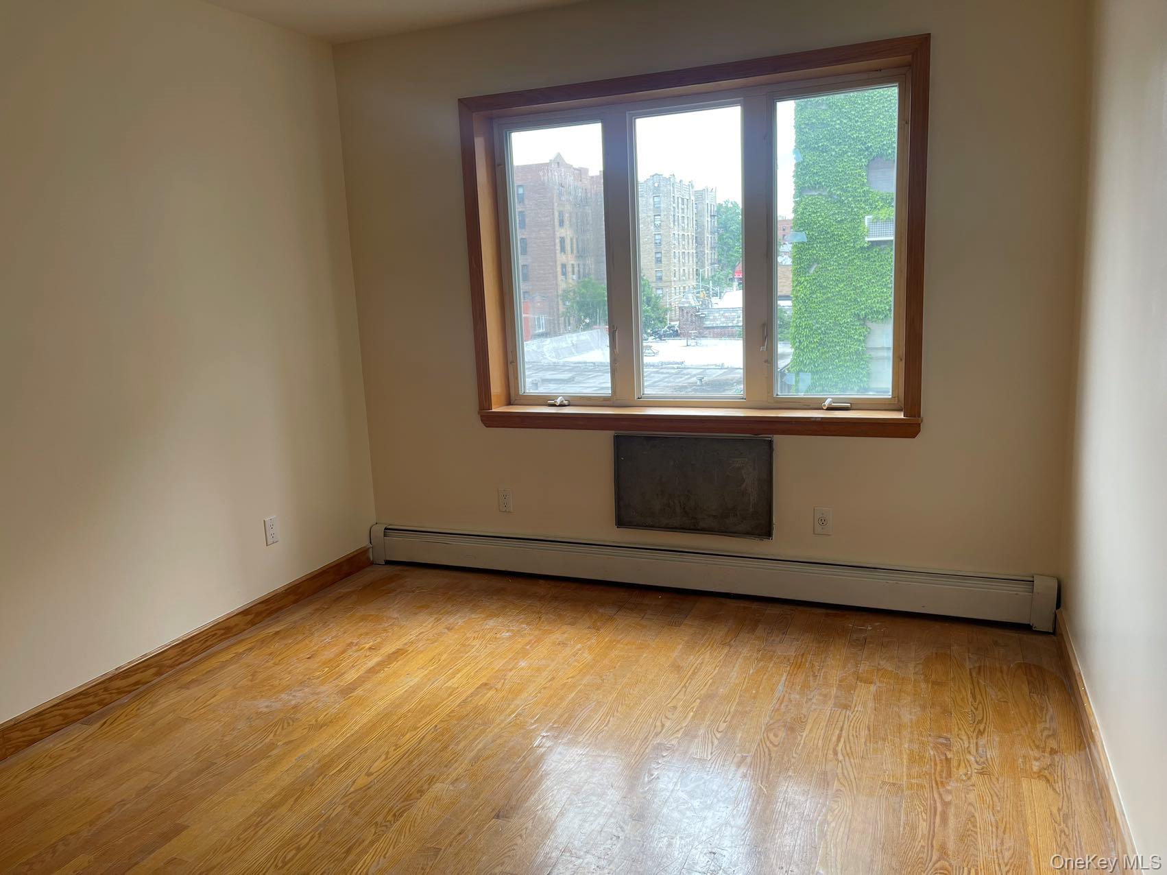 43-07 48th Street, Unit 5A Queens, NY 11104 - Photo 5 of 9 a view of a room with wooden floor and a window