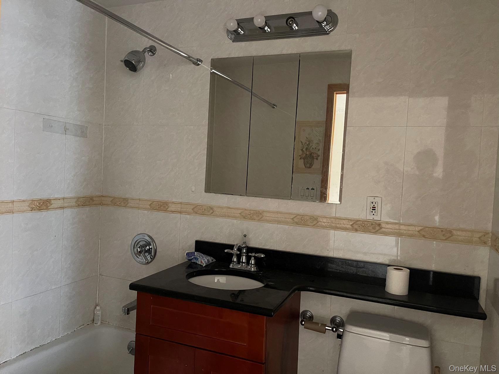 43-07 48th Street, Unit 5A Queens, NY 11104 - Photo 7 of 9 a bathroom with a granite countertop sink and a mirror