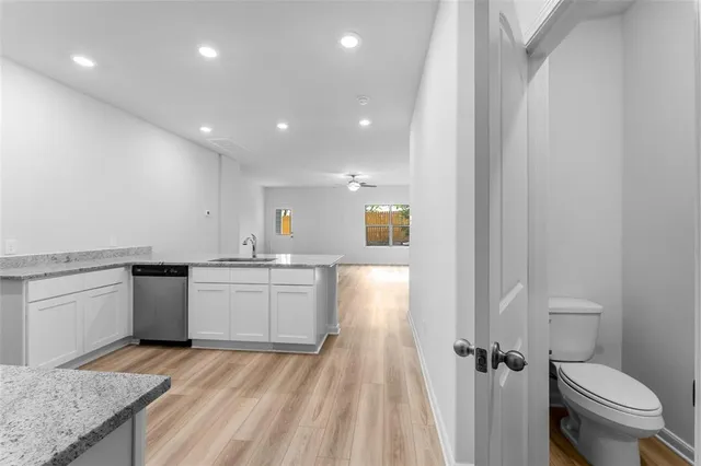 a bathroom with a granite countertop sink mirror vanity and toilet