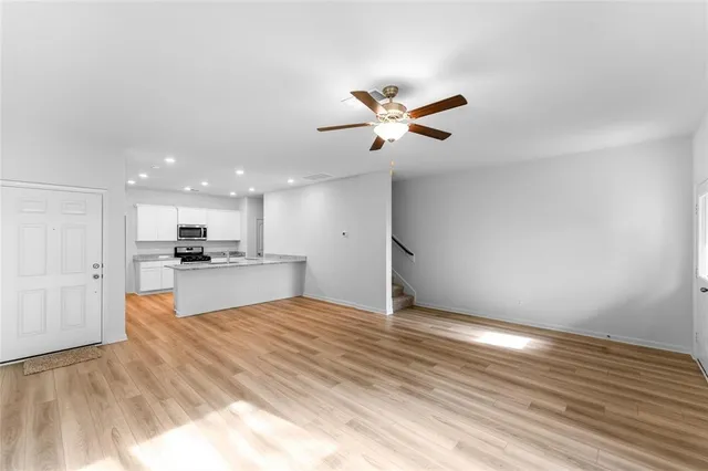 a view of a kitchen with kitchen island a sink stainless steel appliances and cabinets