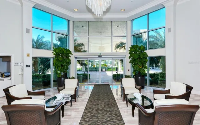 a living room with furniture a chandelier and a large window