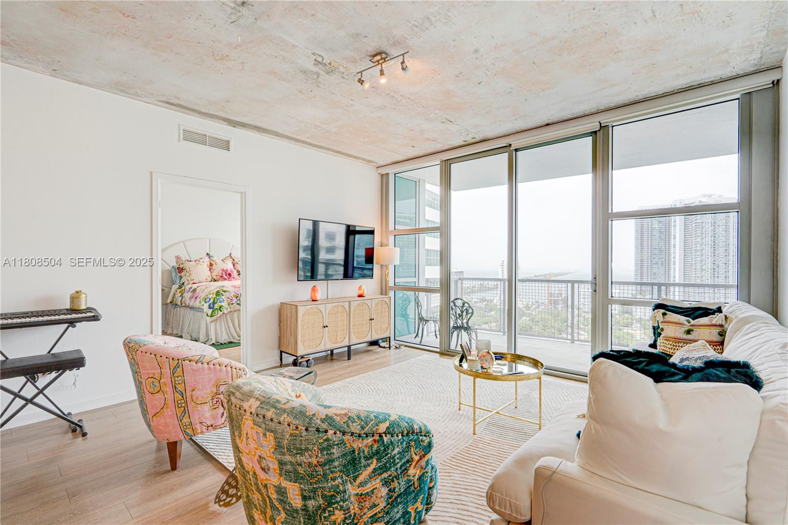 3301 Northeast 1st Avenue, Unit H2304 Miami, FL 33137 - Photo 8 of 27 a living room with furniture and floor to ceiling windows