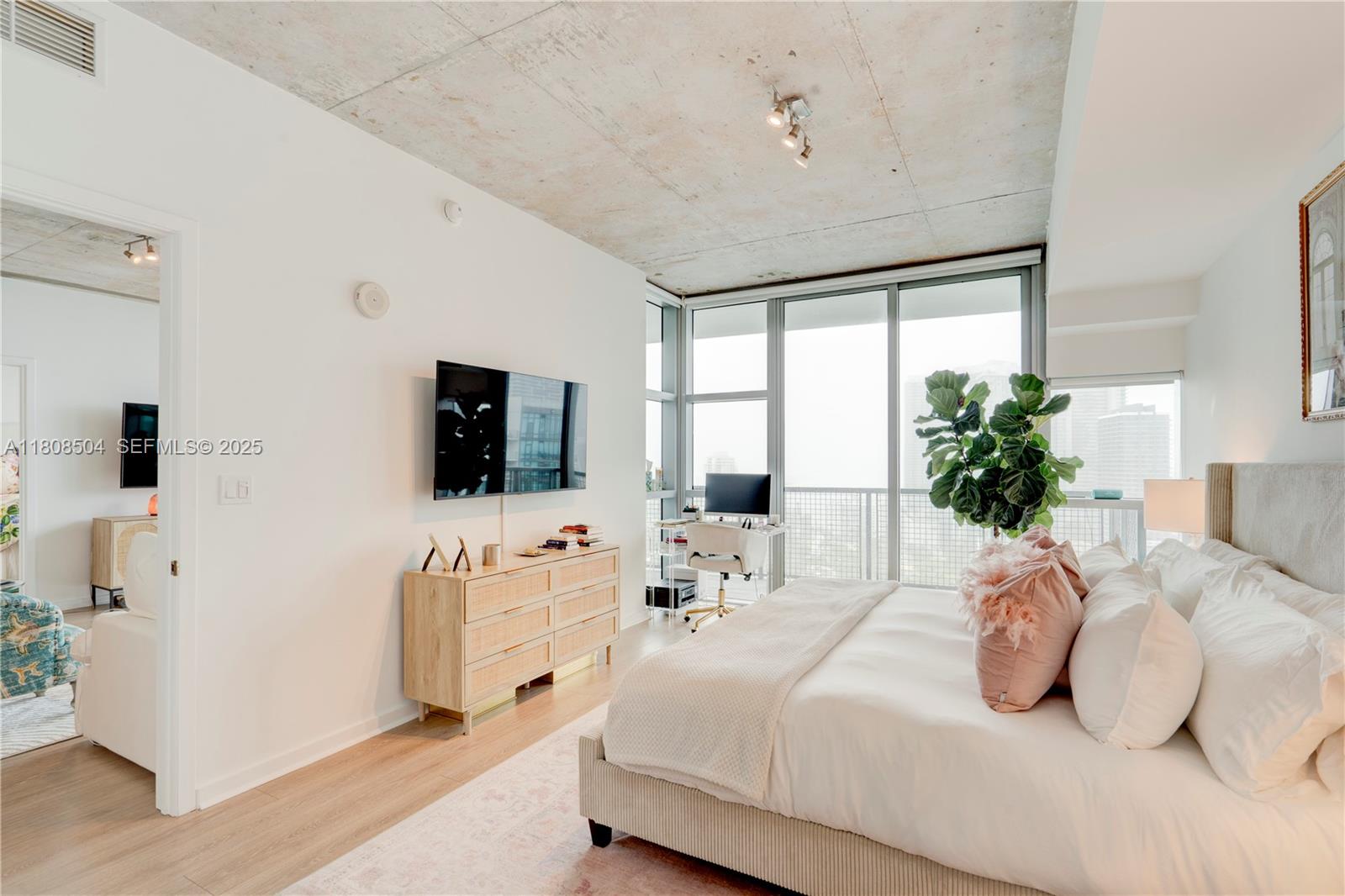 3301 Northeast 1st Avenue, Unit H2304 Miami, FL 33137 - Photo 9 of 27 a bedroom with a bed a flat screen tv and a couch