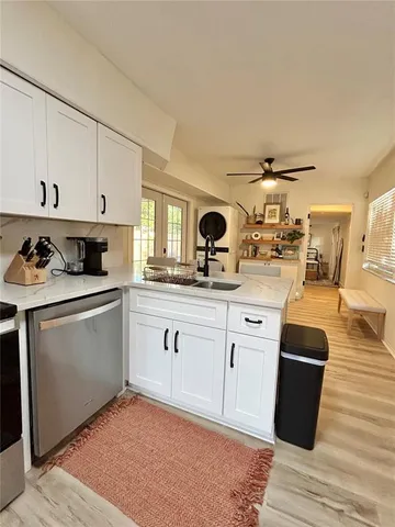 a kitchen with granite countertop white cabinets and white appliances