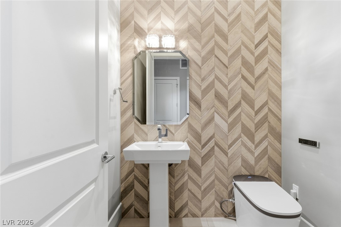 5 Crystal Tree Pass Henderson, NV 89052 - Photo 24 of 67 Herringbone tile accents and a sleek pedestal sink define this chic powder room.