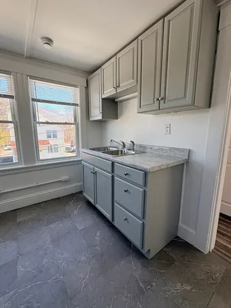 a kitchen with stainless steel appliances granite countertop a sink and a stove next to a window