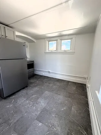 a view of a livingroom with an empty space & a stove top oven