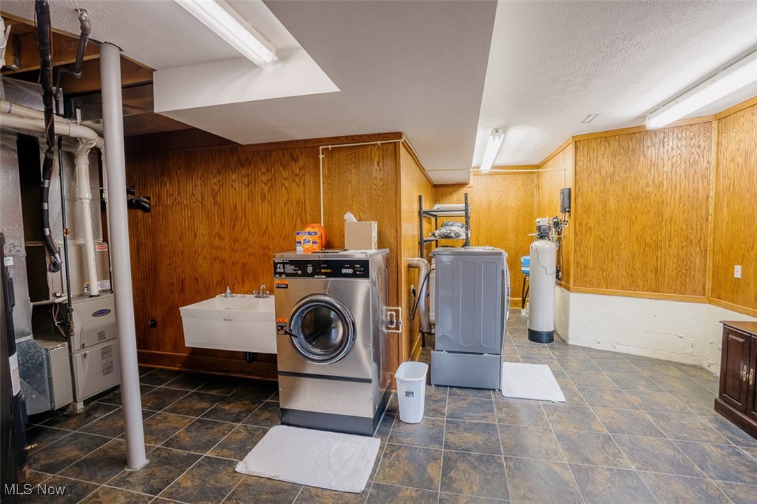 36328 Eagleton Road Lisbon, OH 44432 - Photo 31 of 49 Laundry room with washing machine and dryer, wooden walls, and a textured ceiling