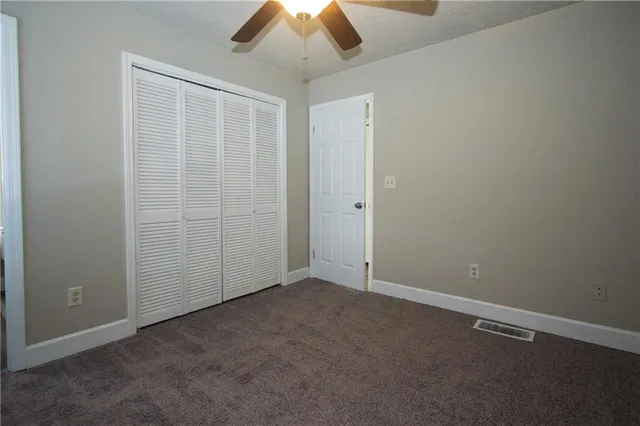an empty room with chandelier fan