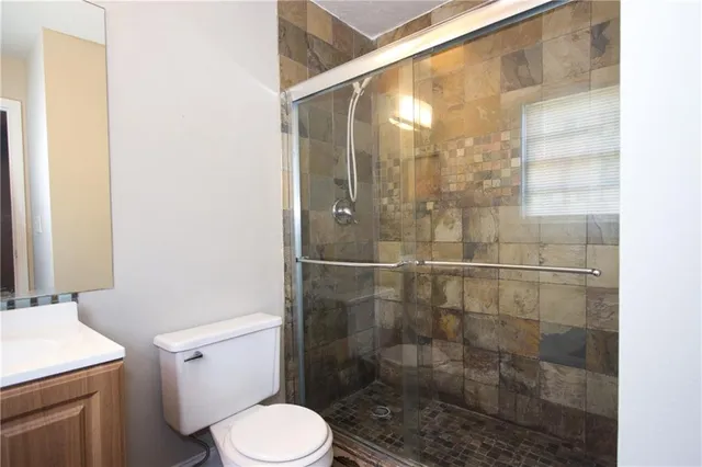a bathroom with a shower a toilet and a sink