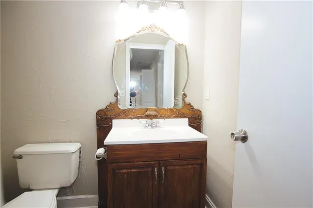 a bathroom with a toilet sink and mirror