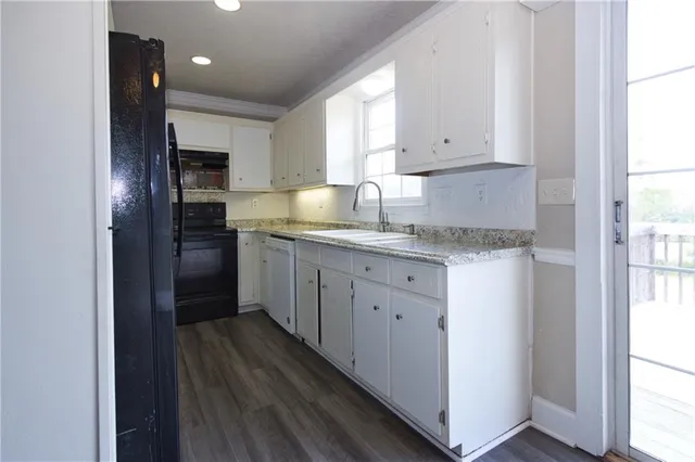 a kitchen with granite countertop cabinets stainless steel appliances a sink and a window