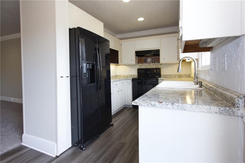 4541 Center Hill Church Road Loganville, GA 30052 - Photo 6 of 25 a kitchen with a refrigerator sink and wooden cabinets