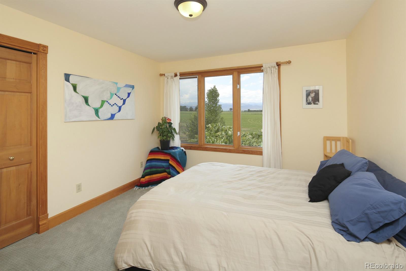 10449 Isabelle Road Lafayette, CO 80026 - Photo 16 of 27 a bedroom with a bed and a large window