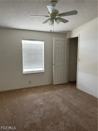 an empty room with a window and a ceiling fan
