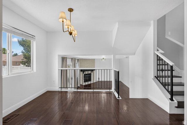 2223 North Pointe Meadow Loop Lehi, UT 84048 - Photo 9 of 56 Spacious interior with dark wood-finish flooring, white walls, and a contemporary brass chandelier