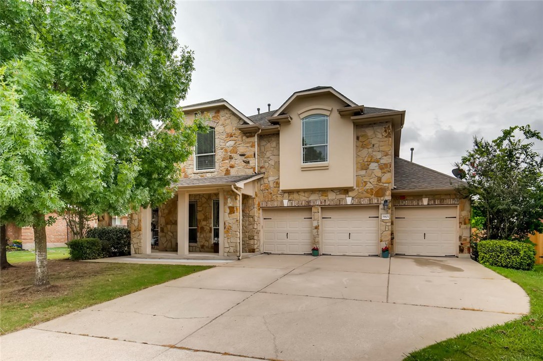 a front view of a house with a yard and trees