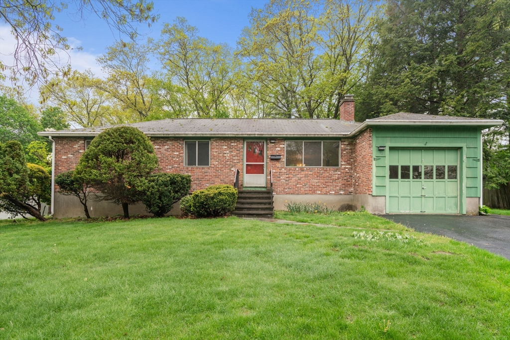 a front view of a house with a garden and yard