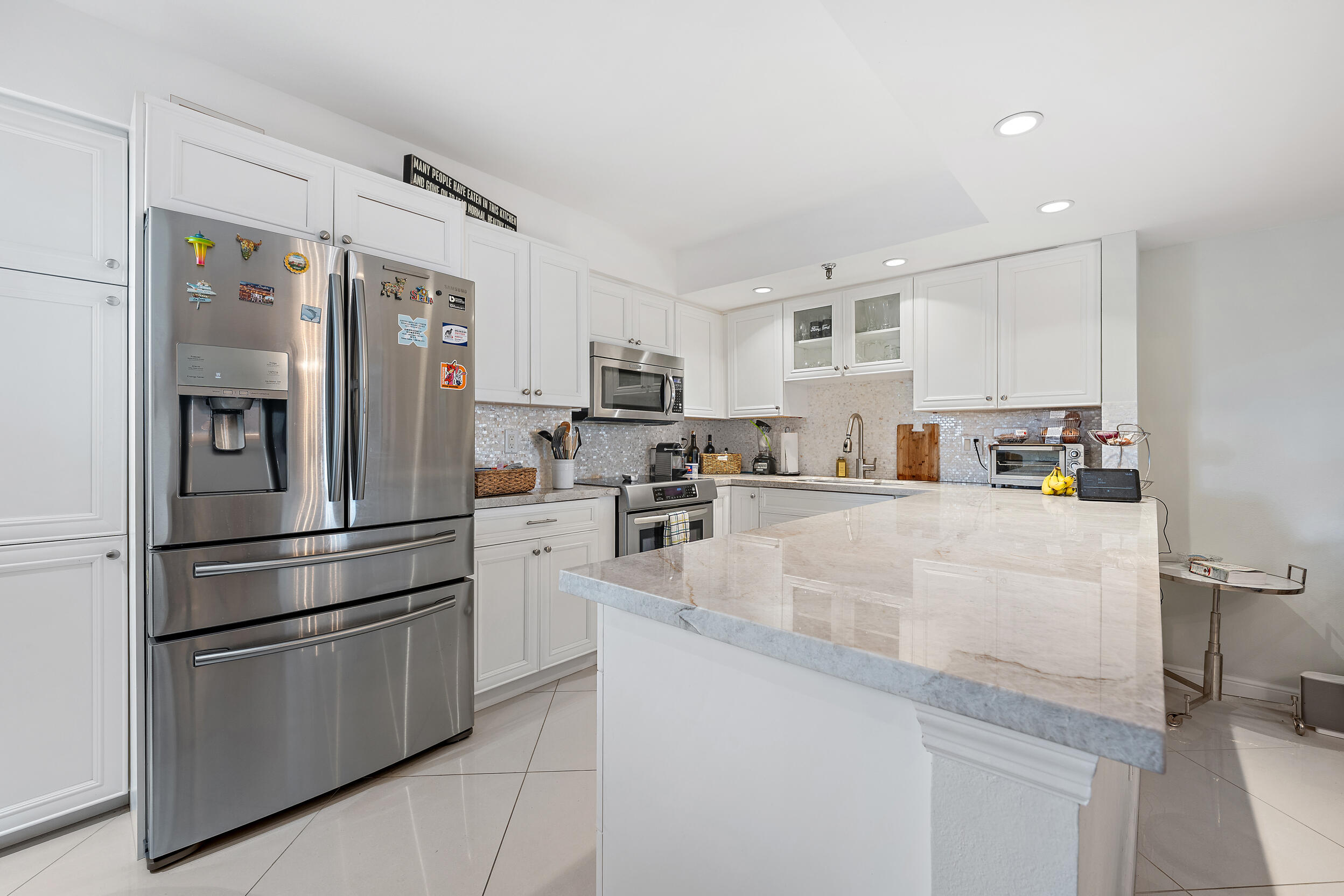 176 Helios Drive, Unit 603 Jupiter, FL 33477 - Photo 6 of 28 a kitchen with stainless steel appliances granite countertop a refrigerator sink and stove