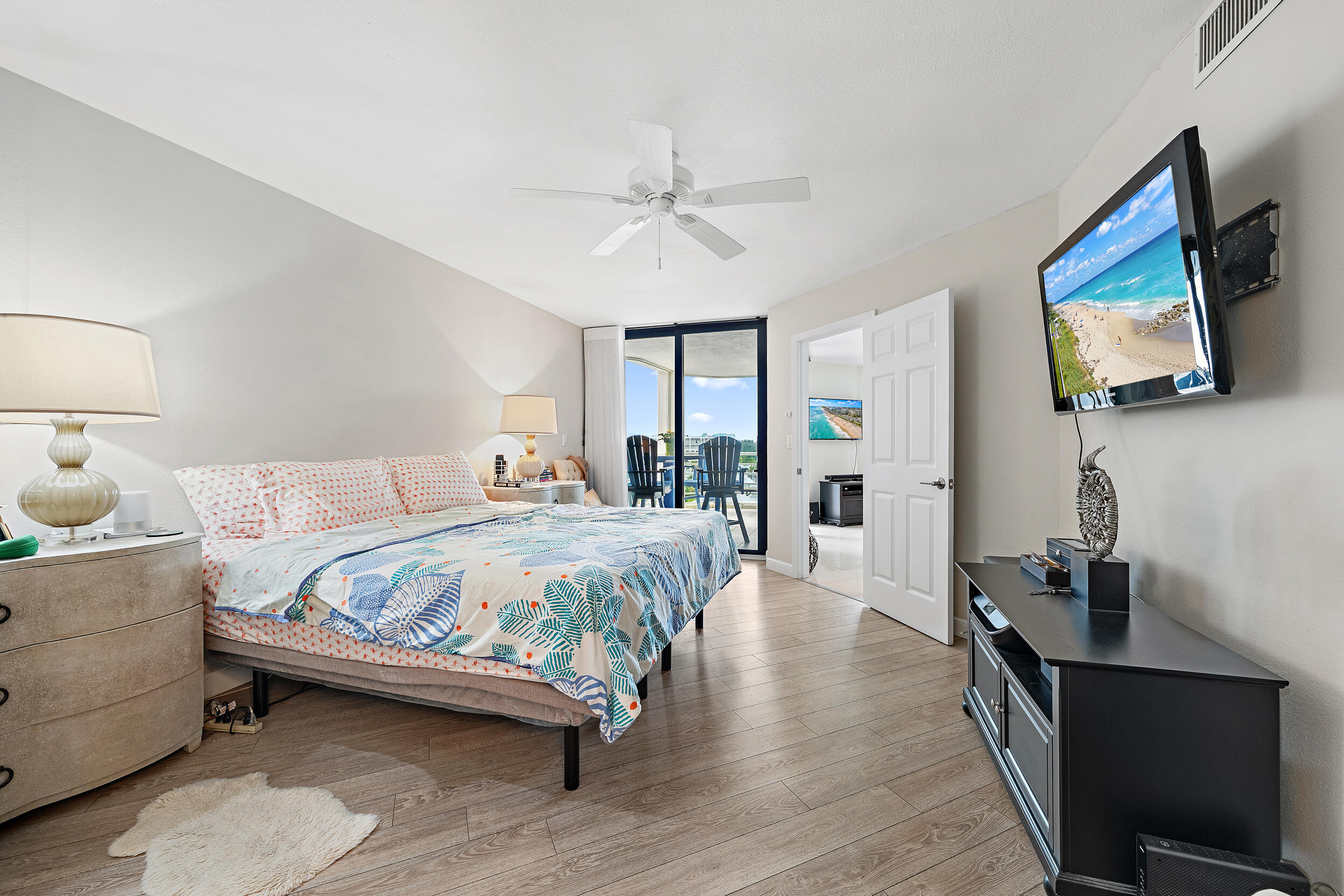 176 Helios Drive, Unit 603 Jupiter, FL 33477 - Photo 10 of 28 a bedroom with a bed and a flat tv screen on dresser