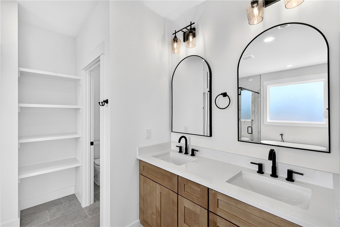 424 Blume Road Anderson, SC 29625 - Photo 21 of 30 Double vanities with sleek black fixtures and arch-top mirrors elevate this modern bathroom's design.