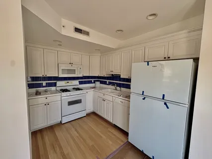a kitchen with white cabinets and white appliances
