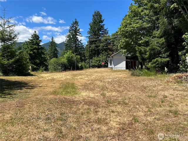 a view of wooden house with a yard