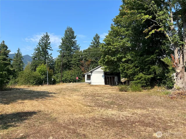a front view of a house with a yard and trees