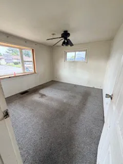 a view of a livingroom with a ceiling fan and window