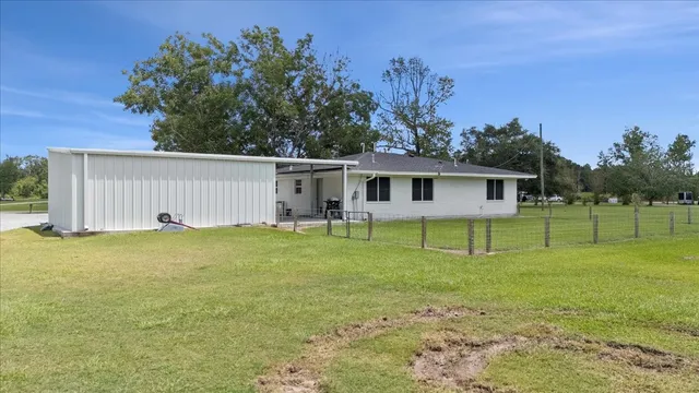 a view of a house with backyard and trees