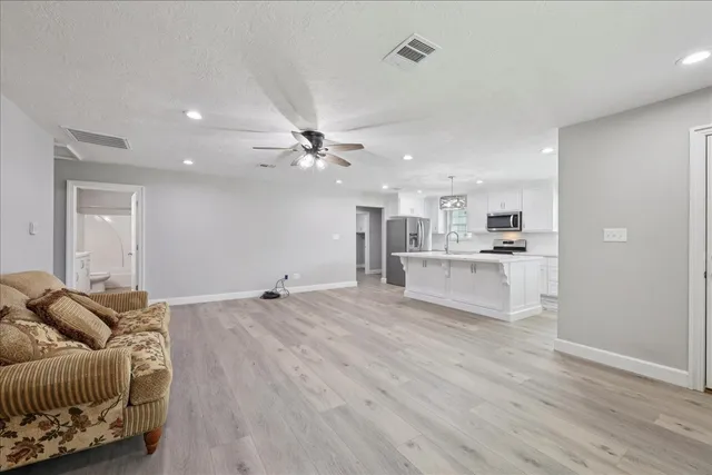 a living room with furniture and kitchen view