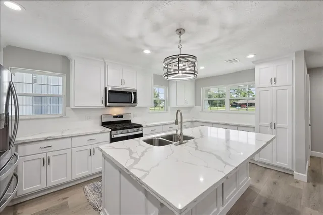 a kitchen with a center island appliances and cabinets