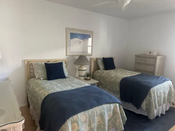 a bedroom with two beds and painting on the wall