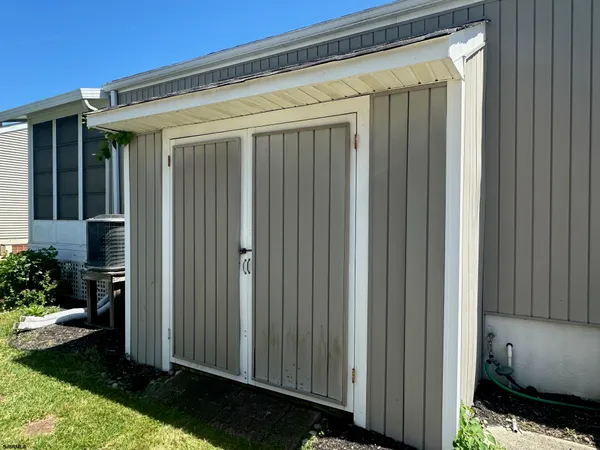 a view of a white house with a small yard and plants