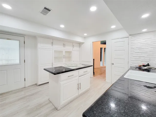 a large kitchen with kitchen island a large counter top space a sink and stainless steel appliances