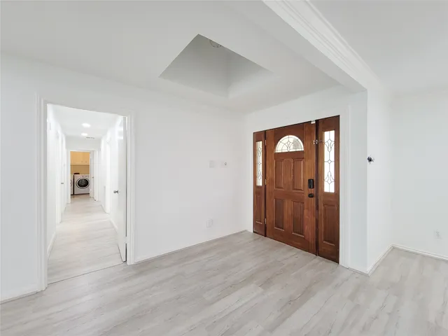 a view of an empty room with wooden floor and closet
