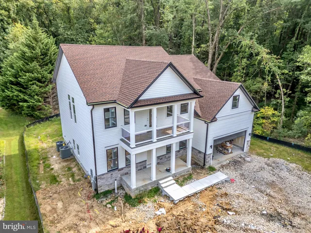 a view of house with garden and tall trees