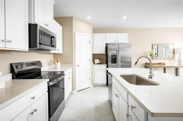 a kitchen with stainless steel appliances granite countertop a sink a stove a refrigerator and a microwave