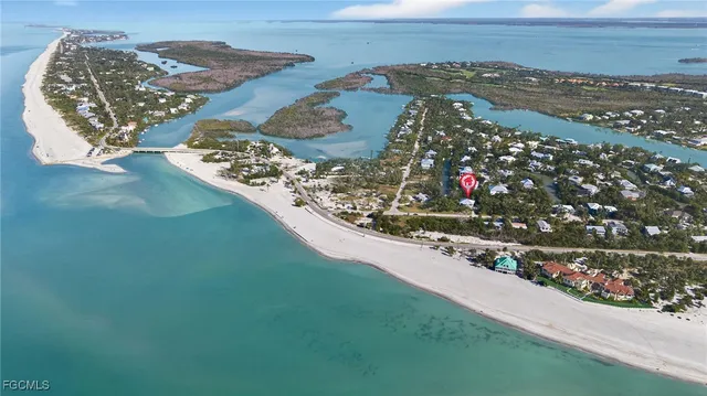 a view of a white house with large windows and a small yard