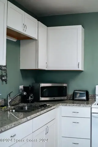 a kitchen with stainless steel appliances granite countertop a sink a stove and microwave