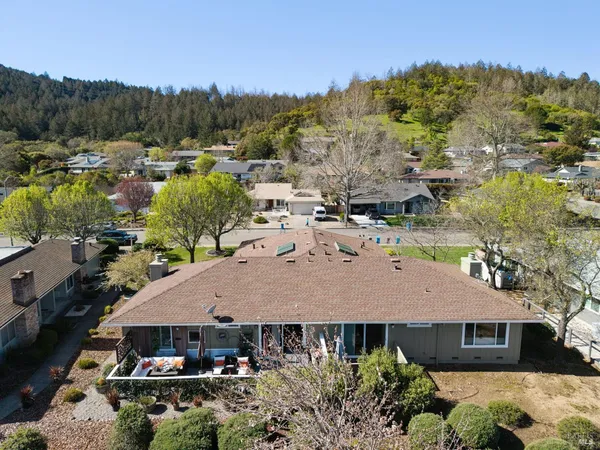 an aerial view of residential houses with outdoor space and trees