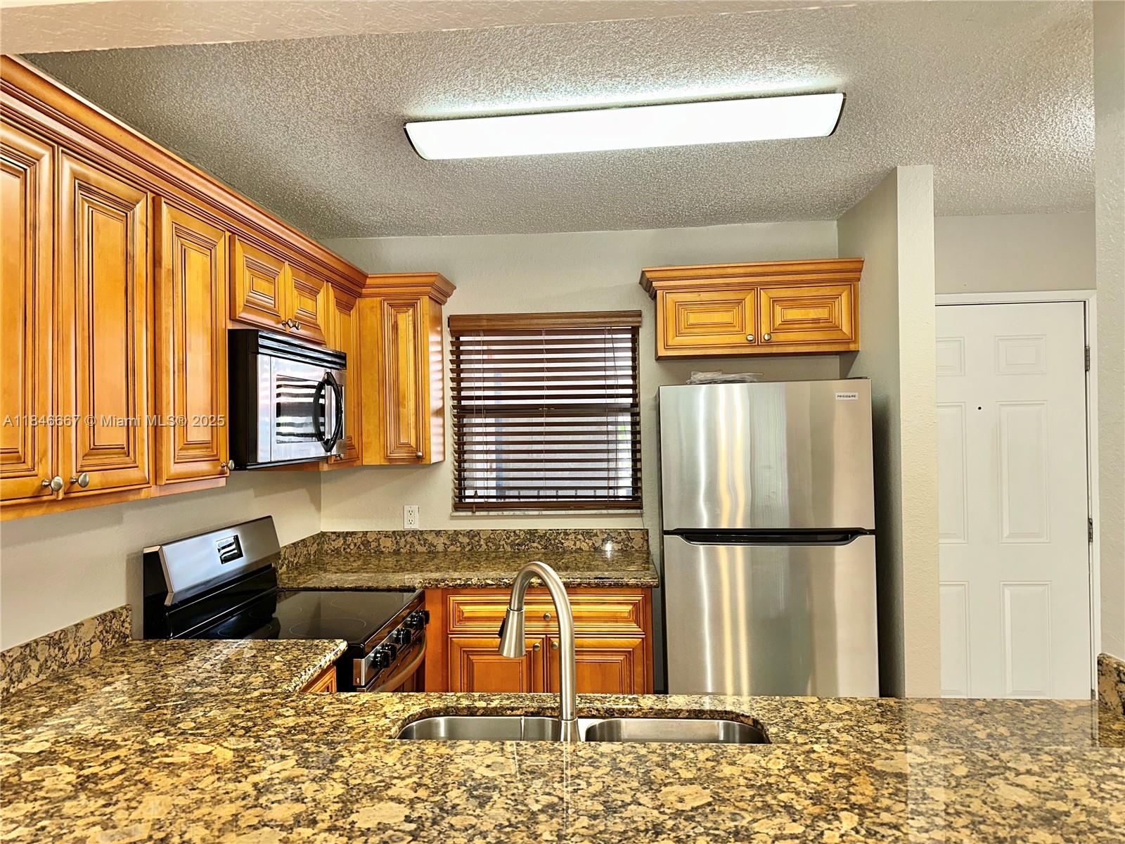 1620 Balfour Point Drive, Unit G West Palm Beach, FL 33411 - Photo 1 of 15 a kitchen with stainless steel appliances granite countertop a refrigerator and a sink